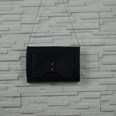 Pochette aspect cuir decoree de grand noeud et deux clou